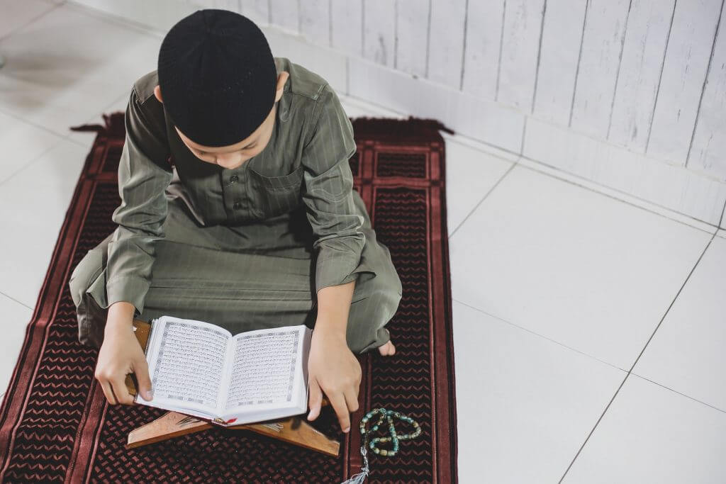 Muslim Boy Reading Quran on Jai Namaz